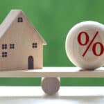 Wooden house and percentage ball on a seesaw.