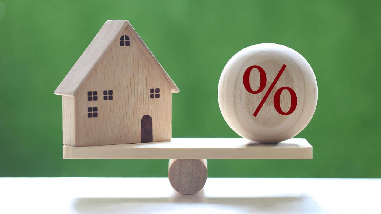 Wooden house and percentage ball on a seesaw.