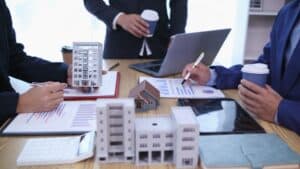 group of businessmen and investors discuss investing in real estate and jointly plan investments in construction projects of condominiums and apartments for sale and rent. investment advisory concept