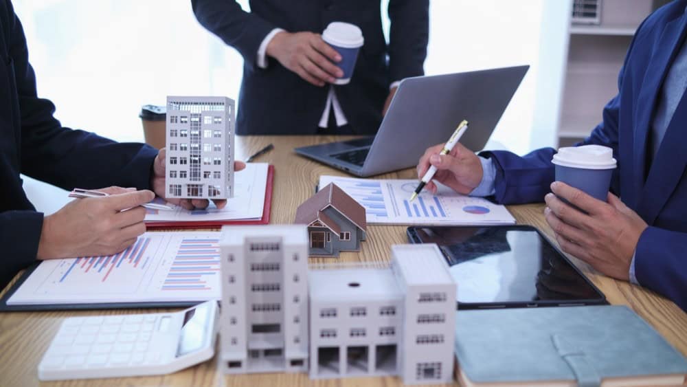 group of businessmen and investors discuss investing in real estate and jointly plan investments in construction projects of condominiums and apartments for sale and rent. investment advisory concept