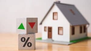 Model house with percentage and arrow blocks representing real estate finance.