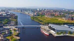Aerial view of Glasgow city with river, bridge, and modern buildings.