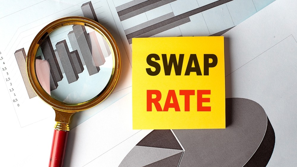 Swap rate concept with financial charts, magnifying glass, and yellow note on desk.