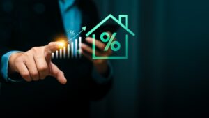 Businessman pointing at rising bar chart with glowing percentage symbol and house icon, representing increasing mortgage rates, home loan growth, interest rate trends, real estate investment finance