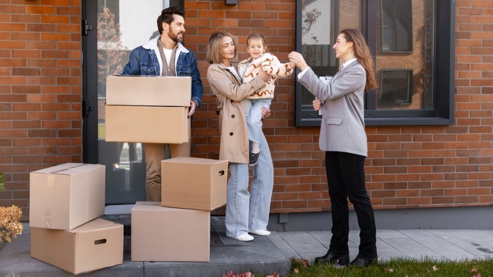 Buying new dream home, a family moving and receiving keys from a real estate agent