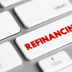 Refinancing is the replacement of an existing debt obligation with another debt obligation under a different term and interest rate, text concept button on keyboard
