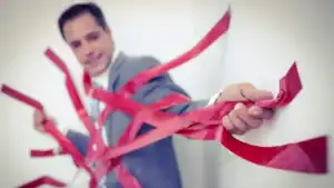 Businessman entangled in red tape representing bureaucratic challenges.