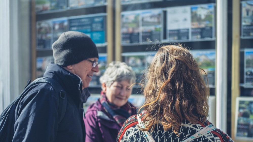 People discussing mortgage options at a real estate agency.